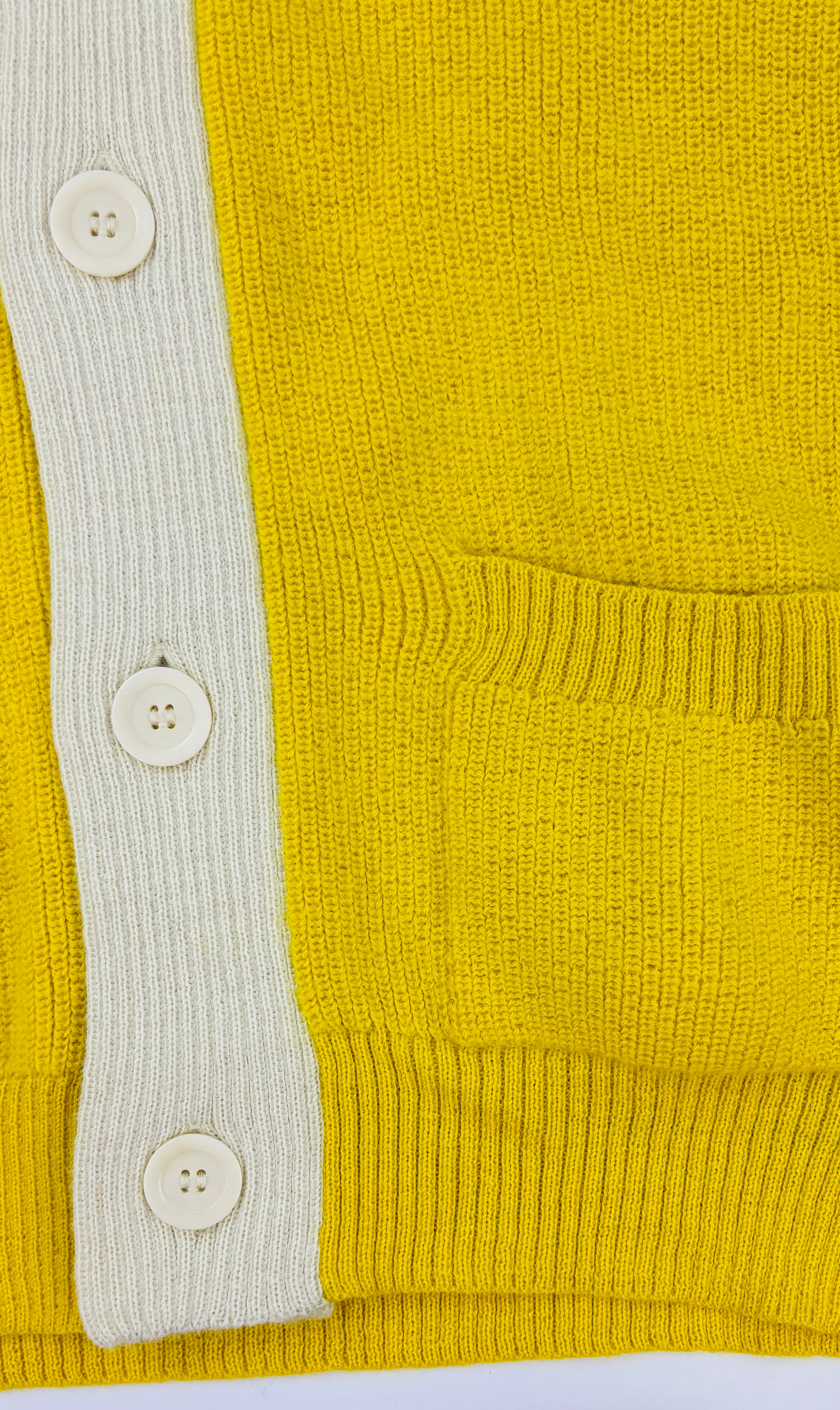 Knopfleiste und Tasche der gelben Alpaka Strickjacke für Herren– weiche, edle Stricktextur.